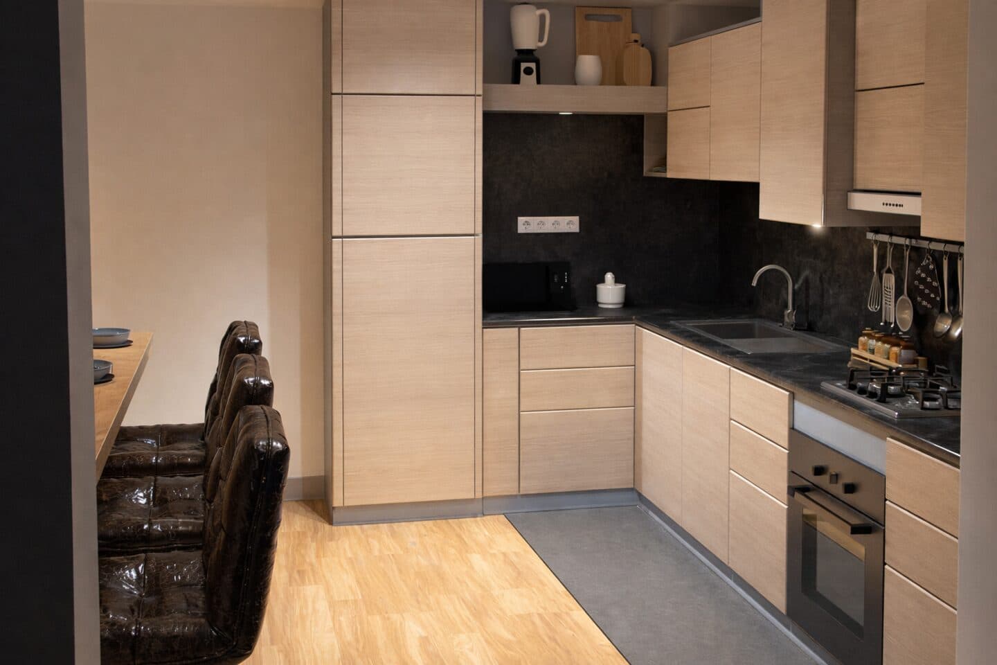 Cucina contemporanea con finiture in legno chiaro e piano scuro